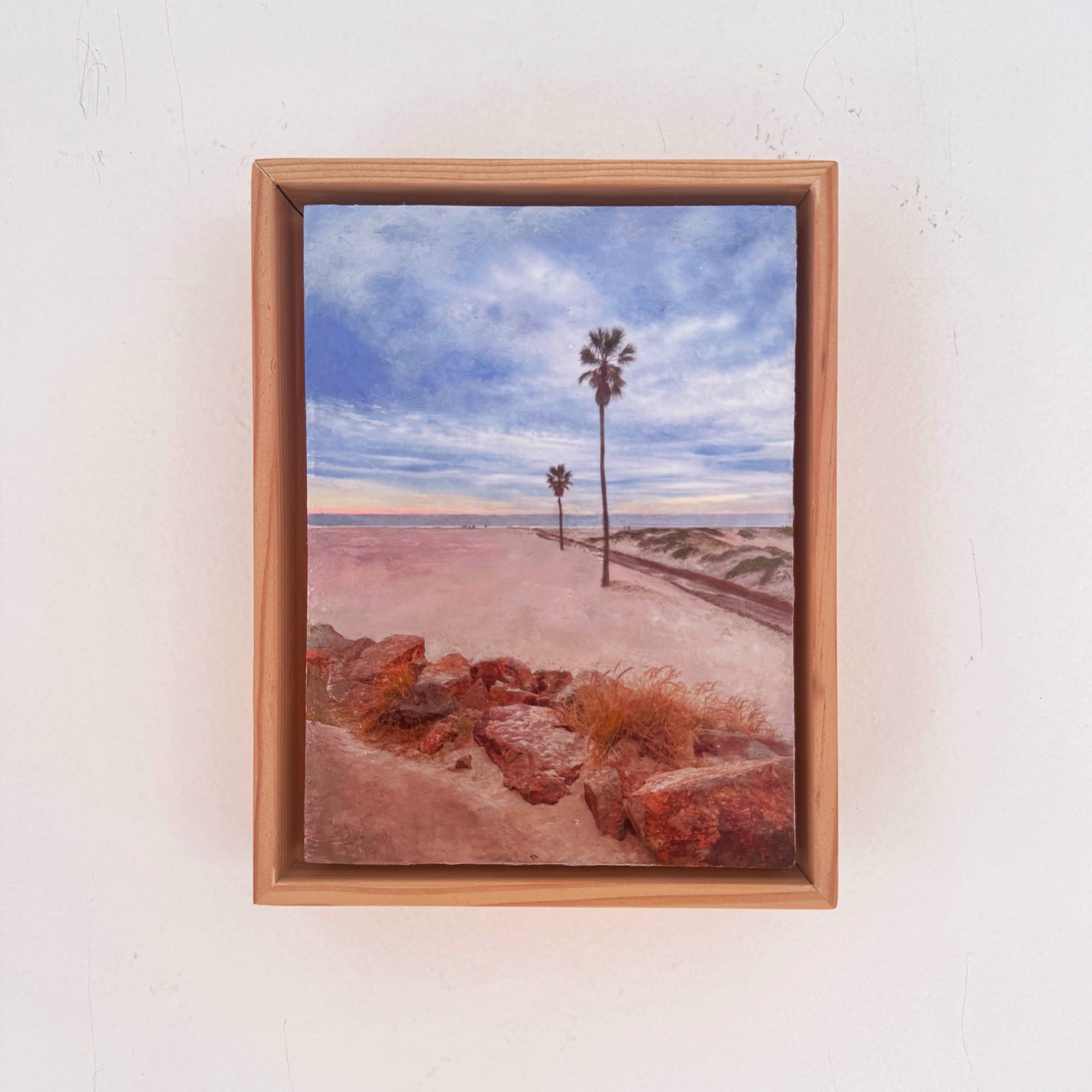Framed artwork of a  Coronado beach scene with palm trees in front of the Hotel Del Coronado
